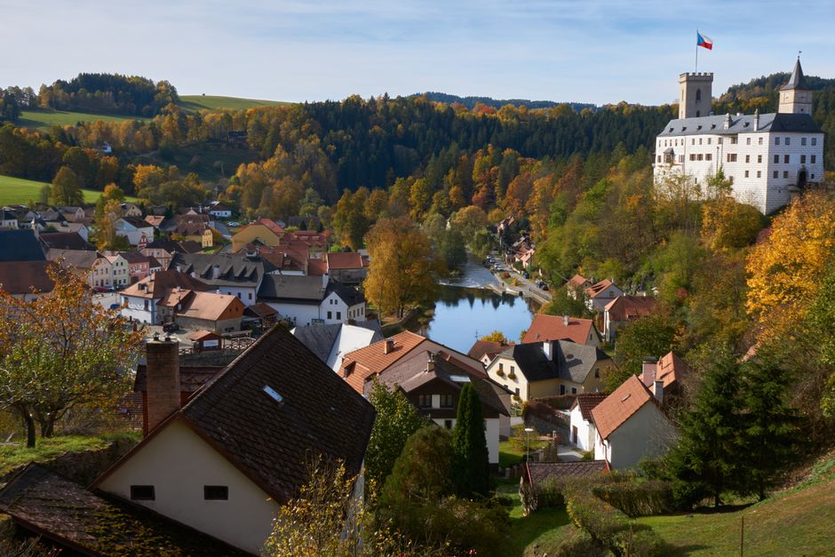 Beautiful autumn landscape of Český Krumlov with colorful foliage and historic architecture.