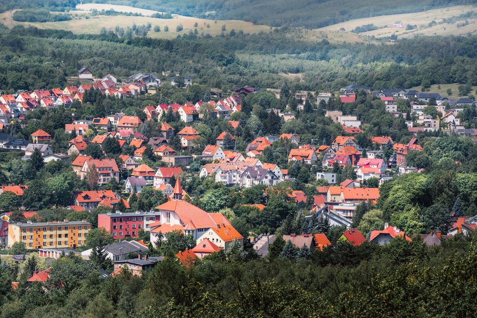 Charming aerial panorama of Wałbrzych town with vibrant rooftops and lush greenery in summer.